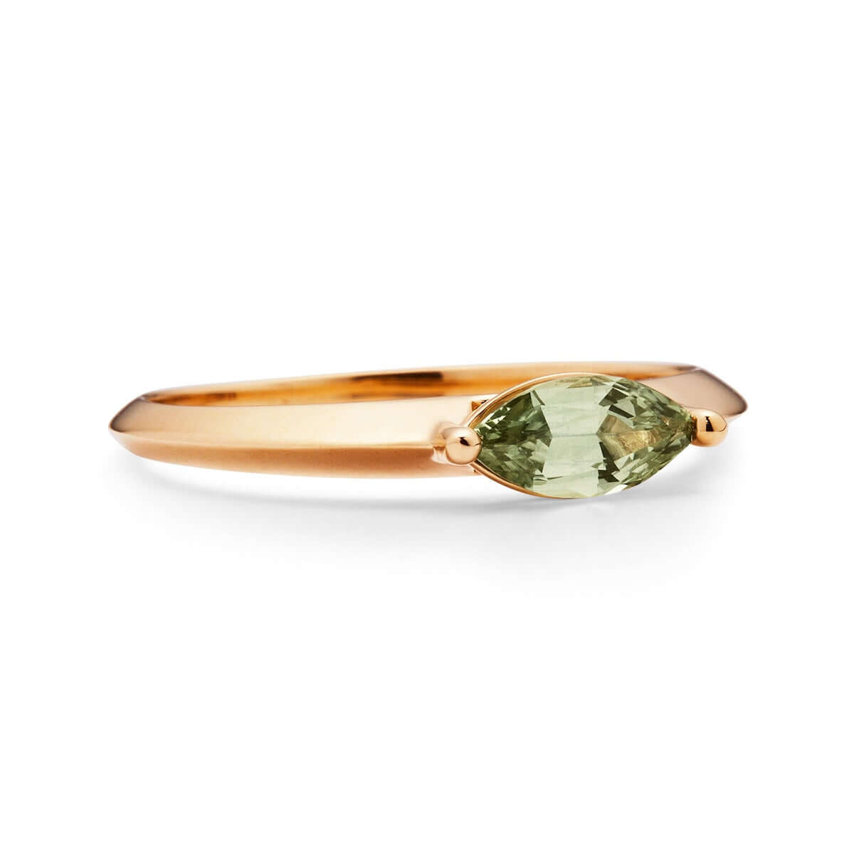 A profile view of a yellow gold ring with a marquise Montana sapphire on white.