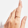 A hand displaying the 'Floe' ring, featuring a gold band and an oval Australian sapphire in a prong setting.