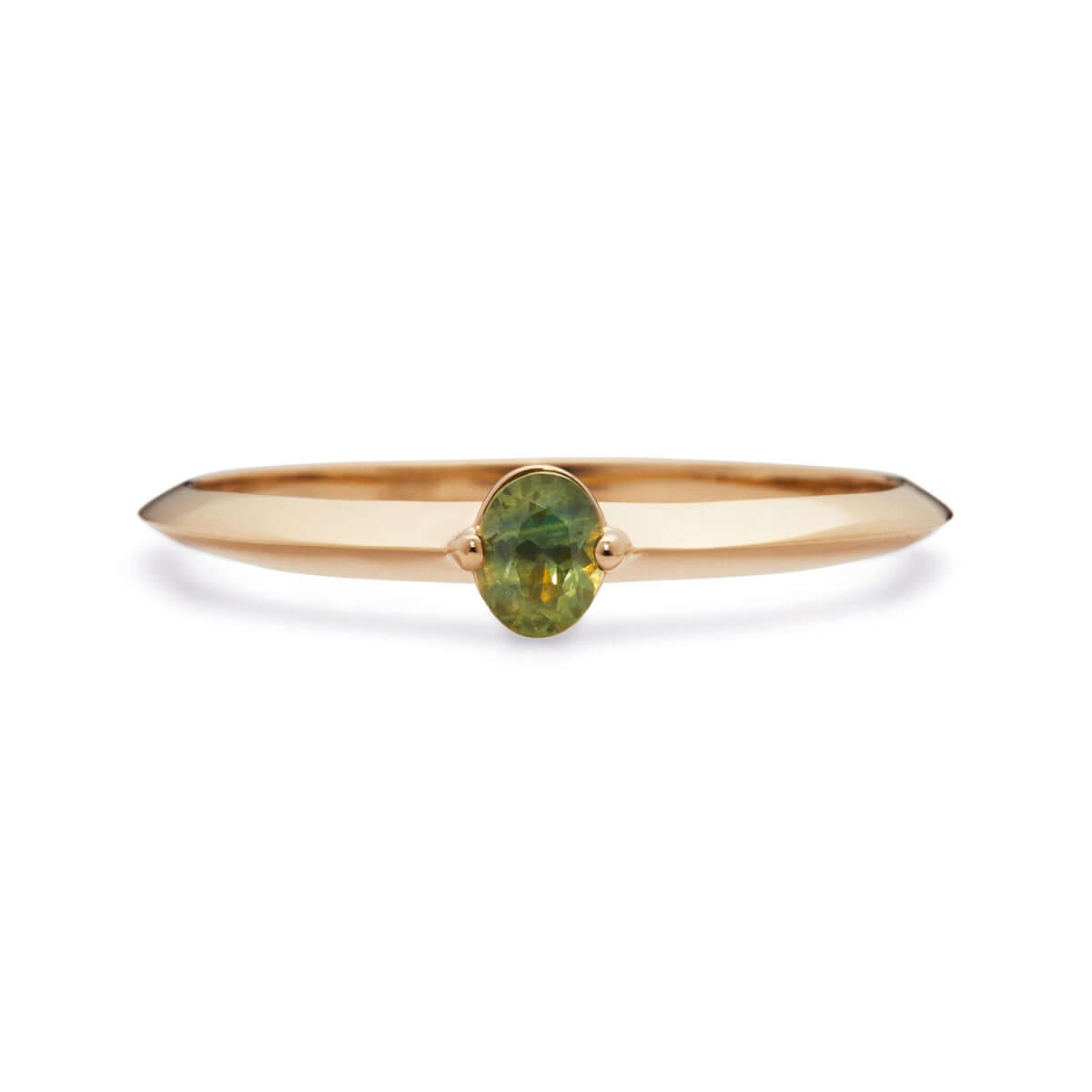 An oval Australian sapphire set in a thin gold band, revealing the stone's mix of greens.