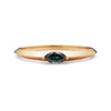 Flora ring from a top-down view, focus on the deep green Australian Sapphire in a sleek 14K yellow gold band with a reflective finish.