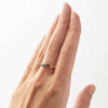 A hand wearing a yellow gold ring with a marquise-cut Australian sapphire.