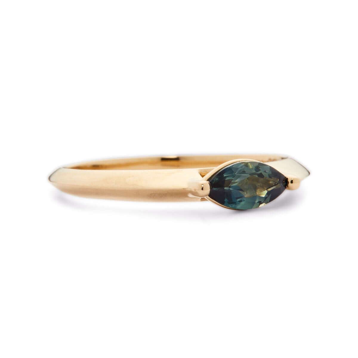 A tilted view of a yellow gold ring with a marquise-cut Australian sapphire against white.