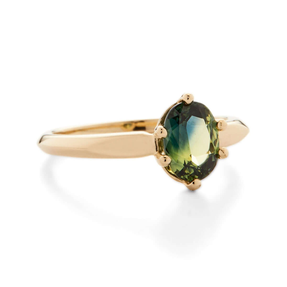 A top-down view of a yellow gold ring showcasing an oval green Australian sapphire.